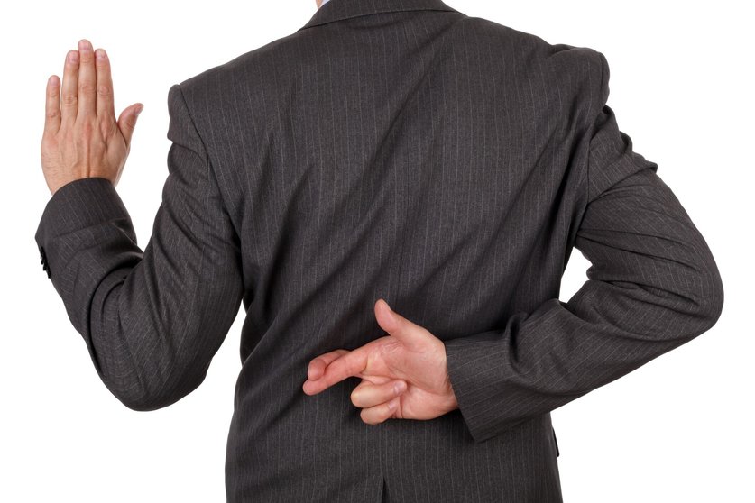 Swearing an oath with fingers crossed behind back concept for dishonesty or business fraud