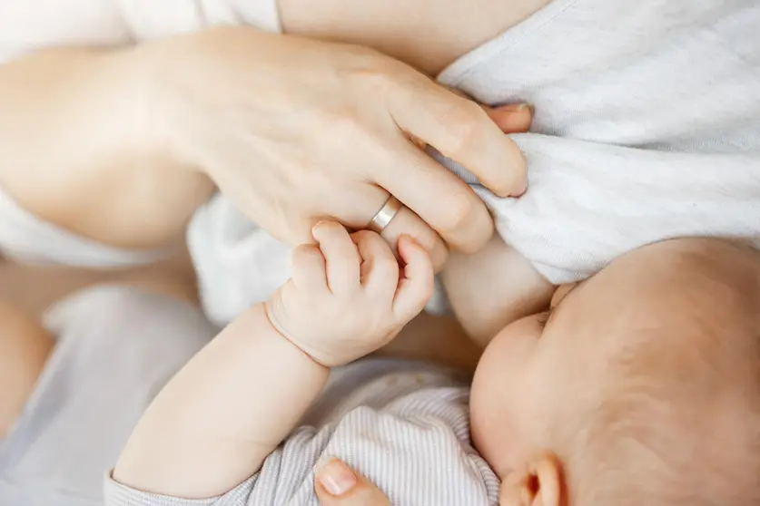 Close up of intimate moment mother lactating her newborn son. Scene of innocence and protection. Family, motherhood and lifestyle concept