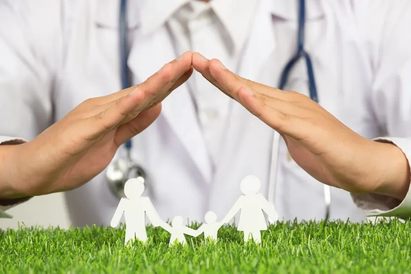 close-up-picture-of-doctor-s-hands-posting-symbol-of-home-above-family-member-model