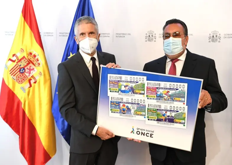 Fernando Grande Marlaska y Miguel Carballeda, con un cartel con las im&aacute;genes de los cupones 2