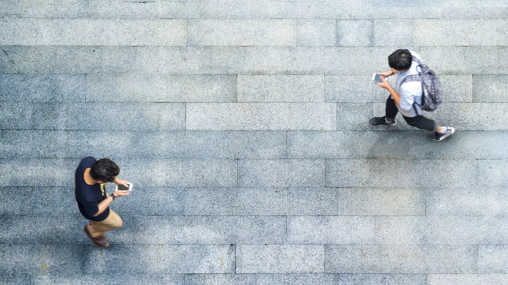 Aerial top view with blur man with smartphone walking converse with busy city crowd move to pedestrian crosswalk