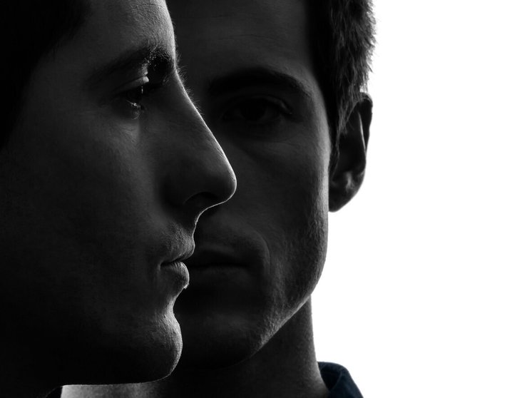 close up portrait  two caucasian young men in shadow  white background