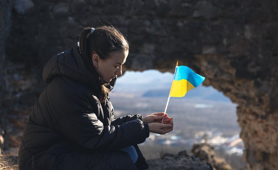 A young sad woman with the flag of Ukraine in her hands, the concept of war in Ukraine.